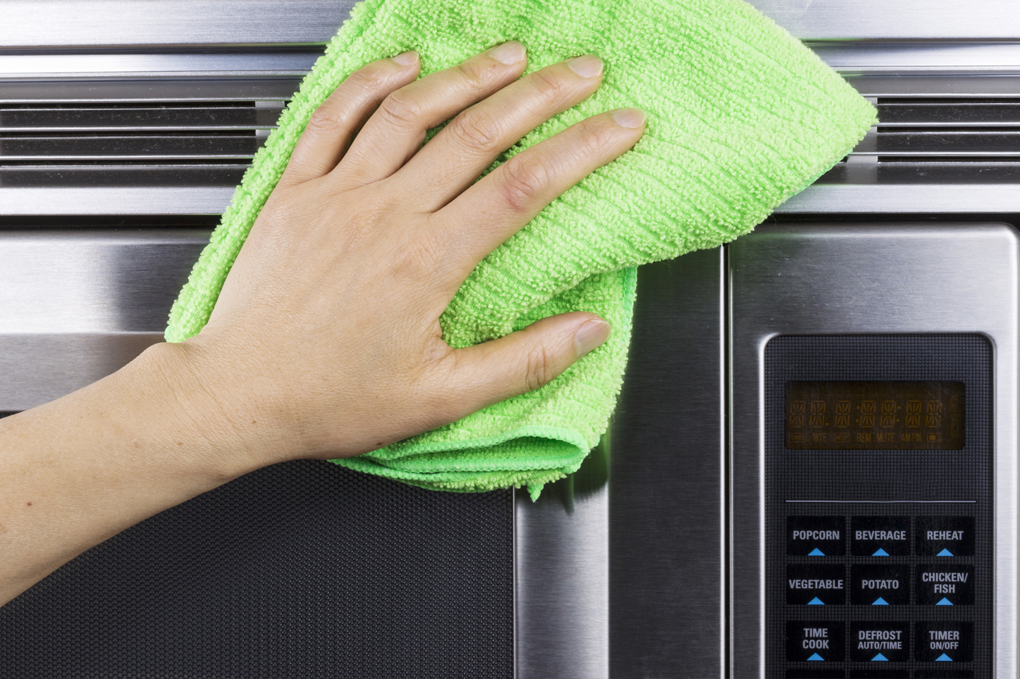 Hand With Microfiber Rag Cleaning Vents Of Microwave Oven